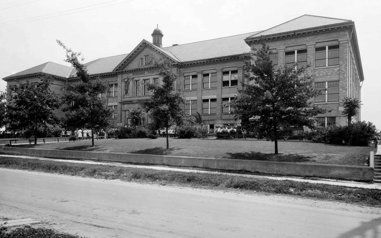 Exterior view of Norquay School with children gathered outside. Source: City of Vancouver Archives Sch N72.2