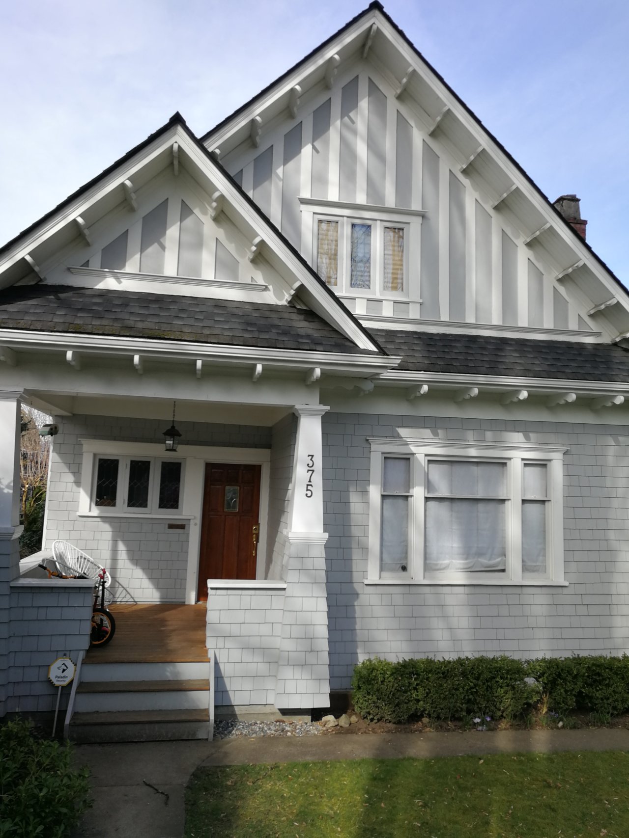 1 1/2 story craftsman house, painted grey with white trim.